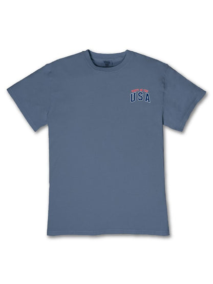 Blue tee with "Home of the USA" in small red and white text on upper left chest. Available in sizes XS–XL.