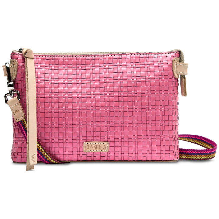 The Midtown Crossbody, Pink: Small rectangular bag with woven pink texture, beige leather accents, multicolored adjustable strap, zipper closure, and beige leather tassel. Sizes available: One size.