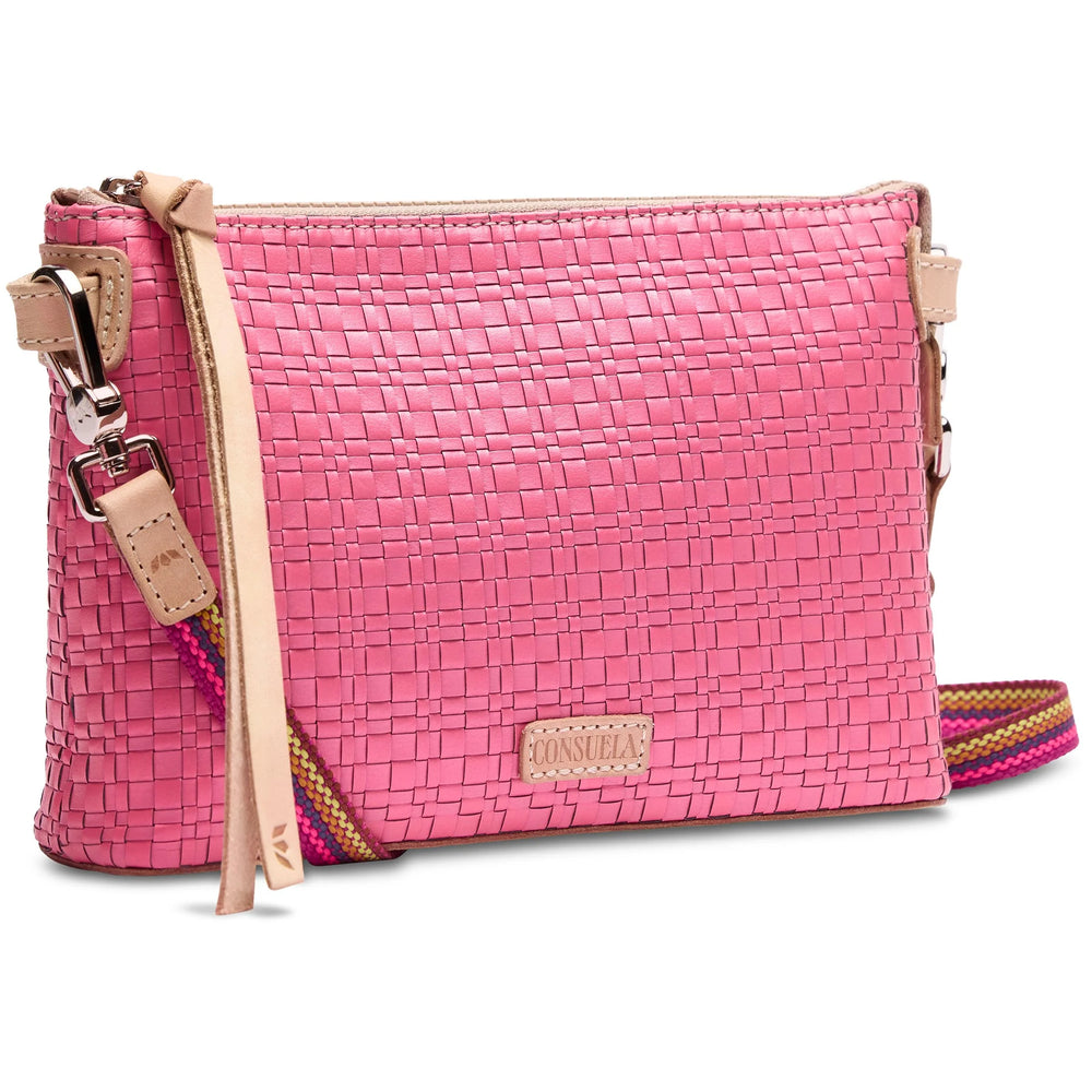 Woven pink crossbody bag with beige leather trim, colorful adjustable strap, front beige "Consuela" leather tag, and decorative leather tassel. Available sizes: One Size.
