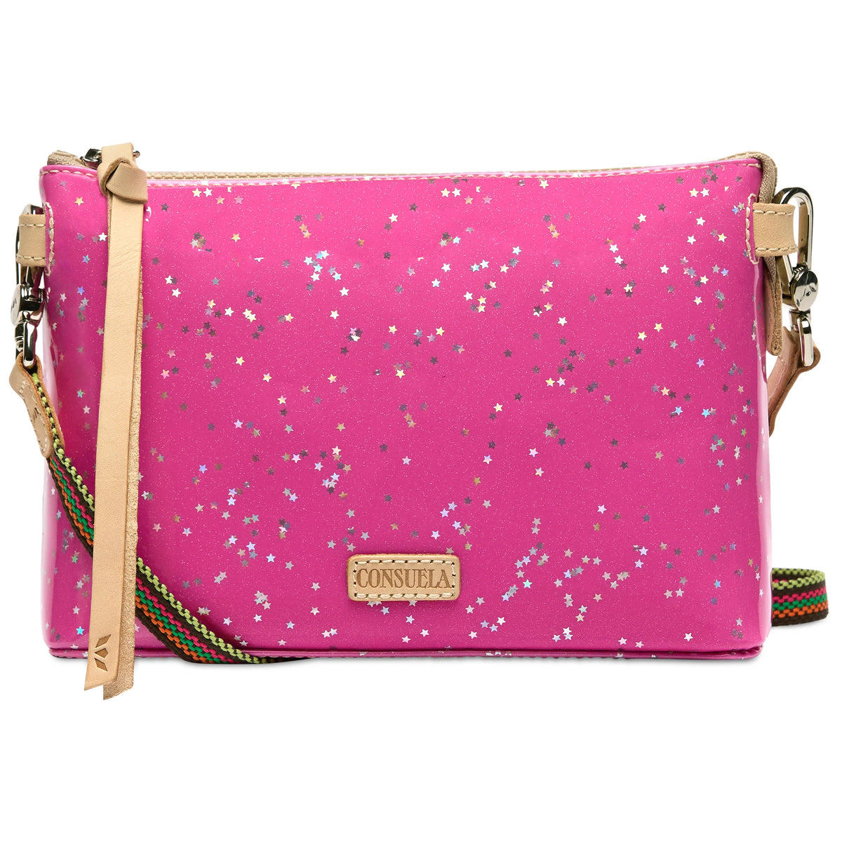 Bright pink glitter crossbody bag with silver star patterns, tan leather zipper pull, striped adjustable strap, and small beige “Consuela” patch on front. Sizes available: Midtown Crossbody.