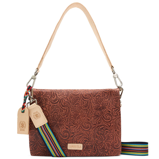 Brown leather handbag with floral embossing, tan handle and tags, detachable multicolored rainbow strap, rectangular shape, flap closure. Can be used as crossbody or wristlet. Available in multiple sizes.