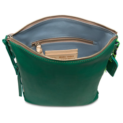 The Tour Crossbody, Teal, unzipped from above shows adjustable strap, blue zip pocket interior. Sizes: Small, Medium.