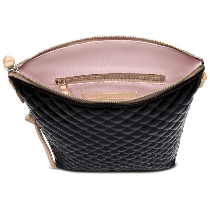 The Tour Crossbody, La Reina: black quilted exterior, light pink interior, beige zipper, inner zip pocket. Sizes: S, M, L.