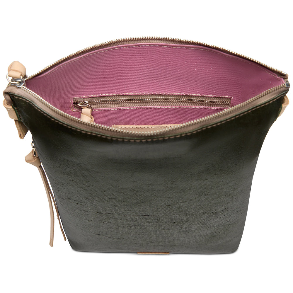 Top view of dark green vertical Tour Crossbody with pink interior, floral embroidery, zip pocket, beige tabs. Sizes: S, M, L.