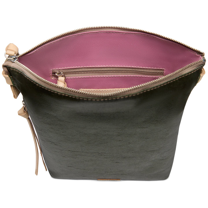 Top view of dark green vertical Tour Crossbody with pink interior, floral embroidery, zip pocket, beige tabs. Sizes: S, M, L.