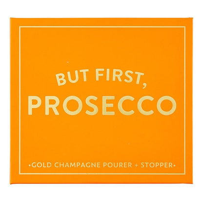 The "Champagne Stopper + Pourer Book Box - But First, Prosecco" is an orange box with magnetic book-style packaging. It features white text: "BUT FIRST, PROSECCO" and includes a gold champagne pourer and stopper for maintaining sparkling wines' freshness. Sizes available: Standard size for typical wine bottles.