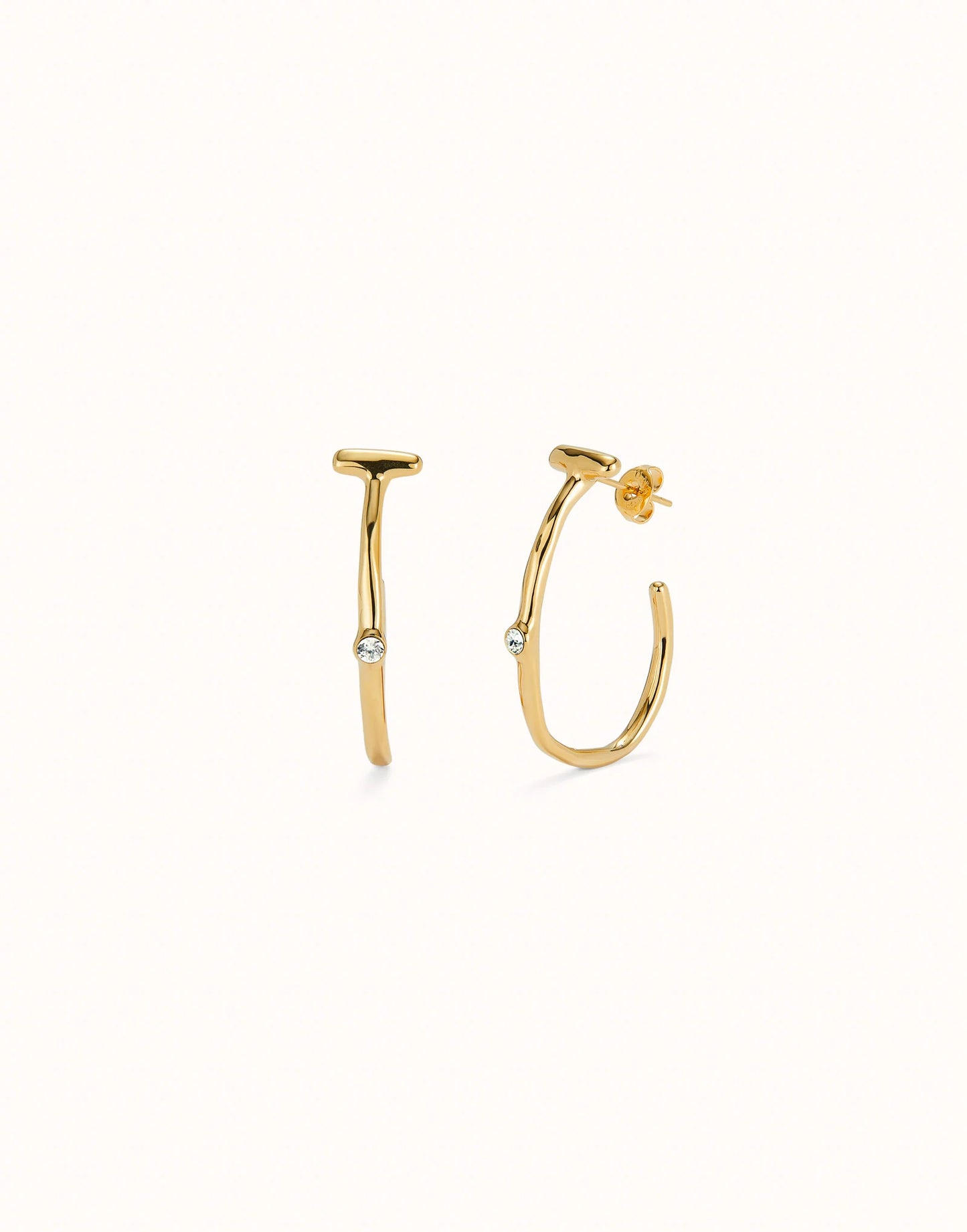 Hoop earrings with white topaz, crafted in 18K gold-plated metal with a modern design. Each earring has a small round white topaz gemstone at the center. Available sizes: small, medium, and large.
