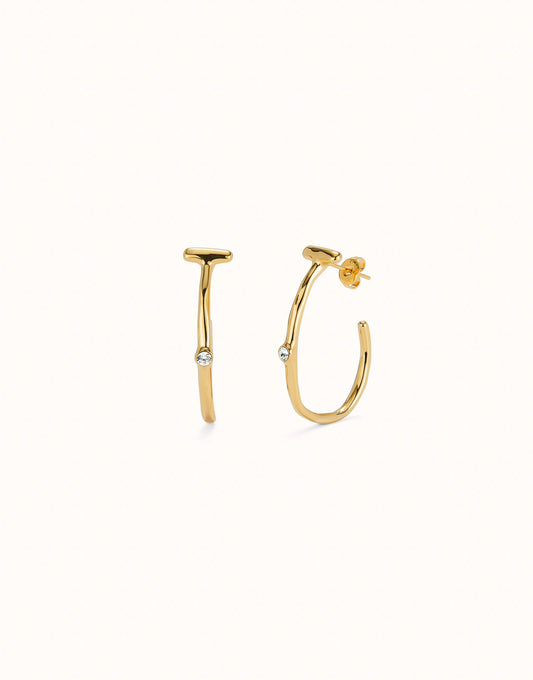 Hoop earrings with white topaz, crafted in 18K gold-plated metal with a modern design. Each earring has a small round white topaz gemstone at the center. Available sizes: small, medium, and large.