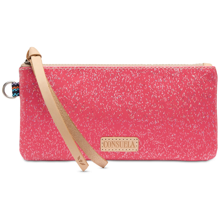 Vibrant pink wristlet with white speckles, tan leather strap, “Consuela” front label, glittery finish, top zipper closure, and keyring attachment. Sizes available.