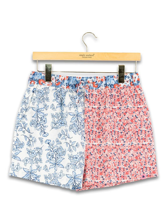 Americana Floral Shorts, blue floral on one side, red/white/blue confetti on other. Sizes: S, M, L, XL.