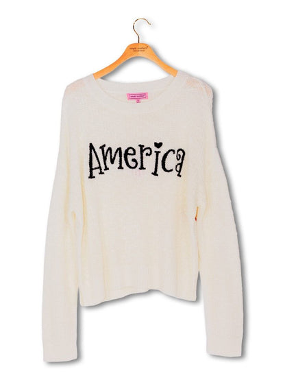 White relaxed-fit sweater with "America" in black embroidery on chest. Available in S, M, L, and XL.