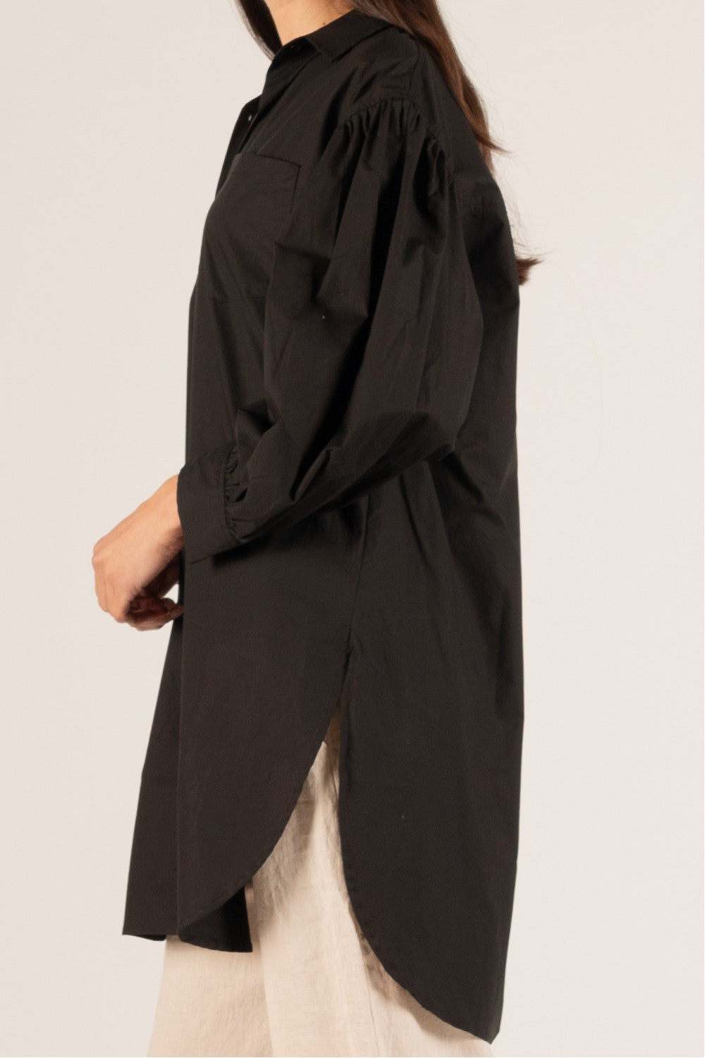 Loose-fitting, long-sleeved black P. CILL Poplin Balloon Sleeve Button Up Shirt with a high-low hemline and puffy shoulders. Features side slit detail. 100% cotton.

Sizes: S, M, L, XL