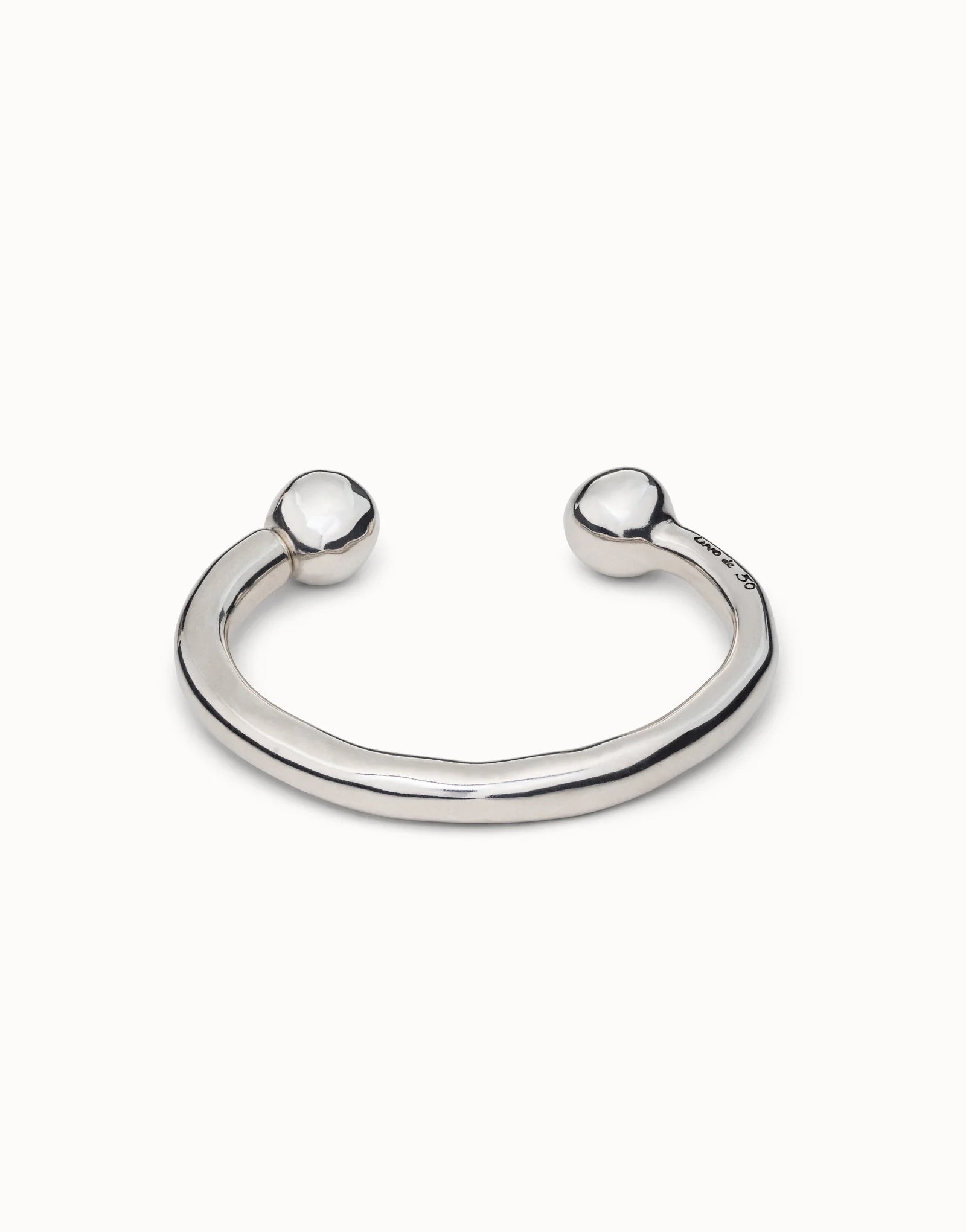 Handmade sterling silver open cuff bangle with polished double ball ends, subtly irregular shape, and smooth reflective finish. Available in multiple sizes.