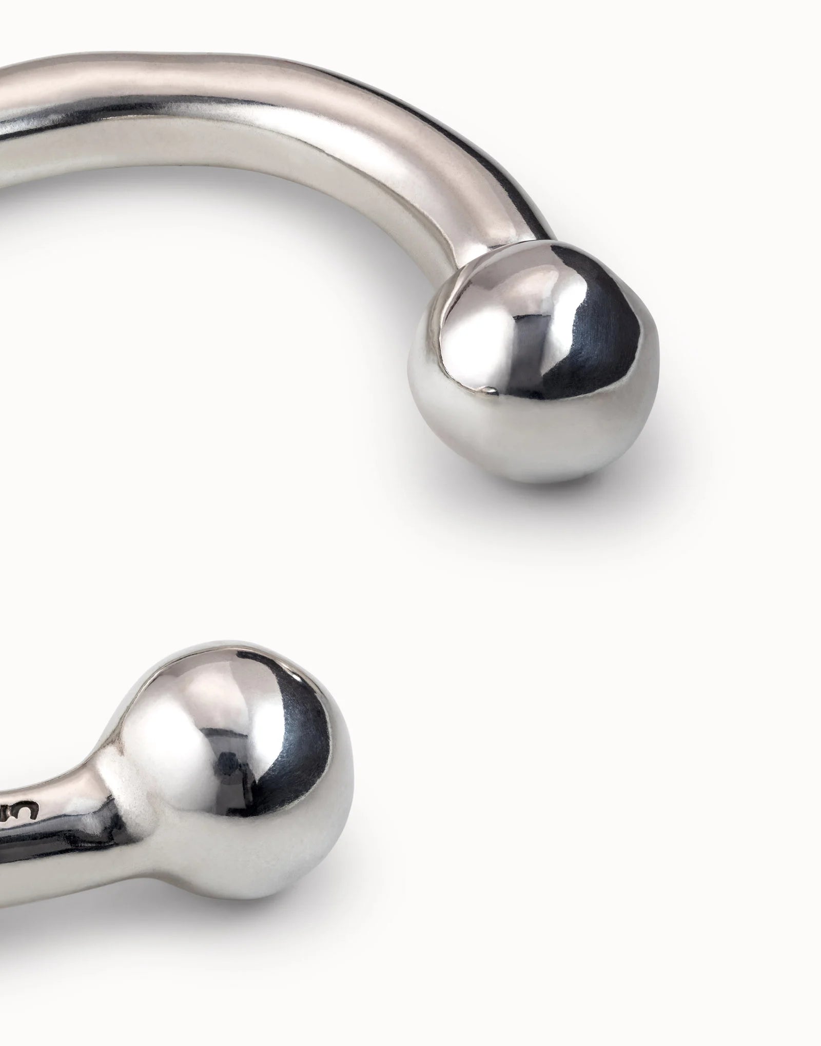 Sterling silver bangle bracelet with curved design and double round ball ends; available in multiple sizes.