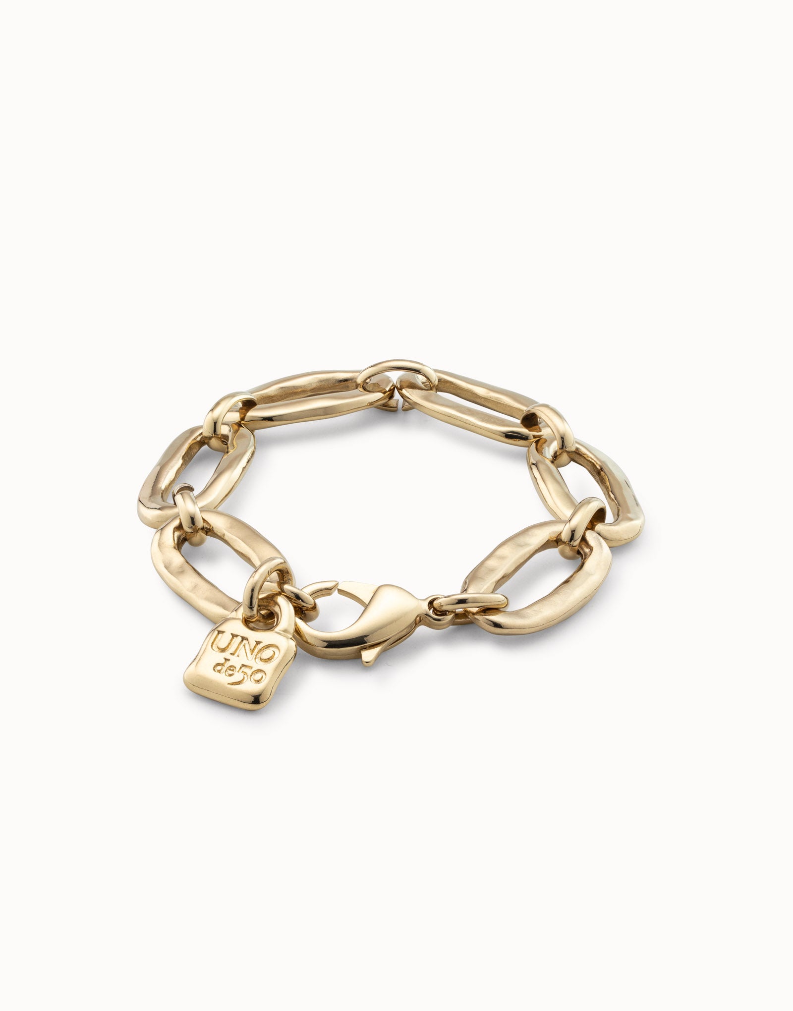 Gold-plated handmade bracelet from Spain with bold oval links, square "UNOde50" tag, and lobster clasp closure; available in small, medium, and large sizes.