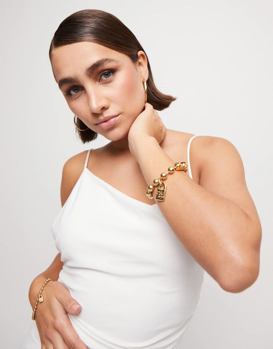 Gold Beaded Bracelet with Padlock Charm shown on wrist; available in small, medium, and large sizes.