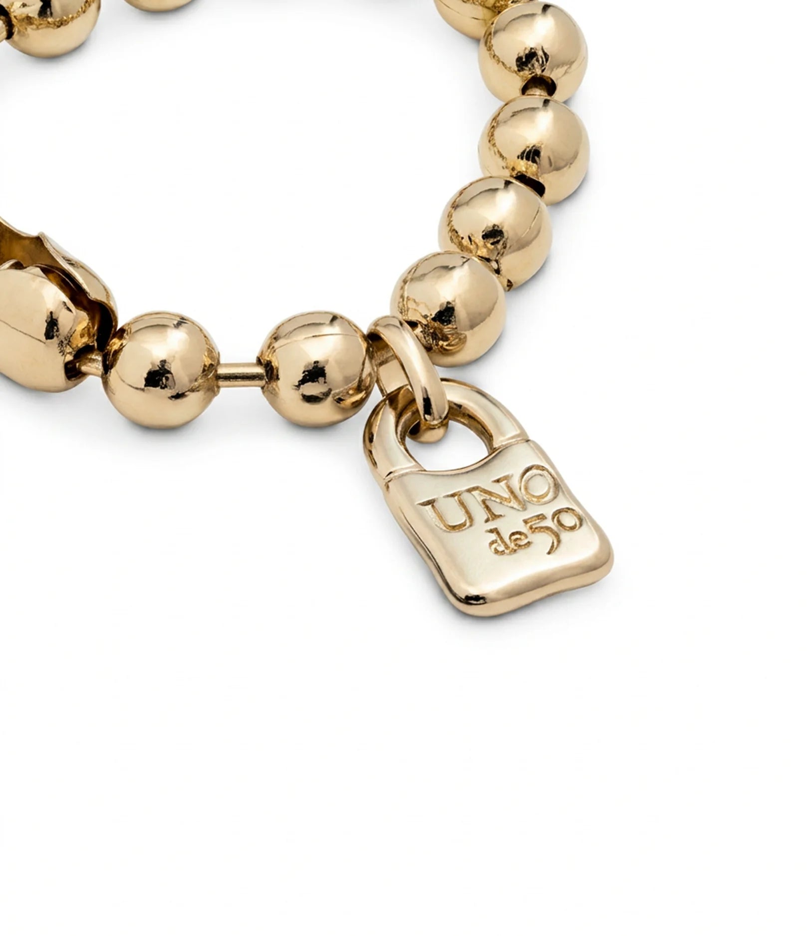 Unisex gold-plated beaded bracelet with a small padlock charm engraved "UNO de 50"; available in multiple sizes.