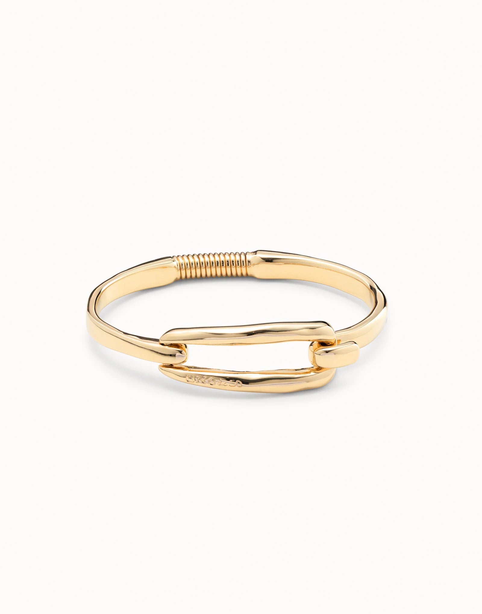Gold-plated bangle bracelet by UNOde50 with buckle, handcrafted in Spain, featuring a hinged clasp and a rectangular curved bar at the center; available sizes: S, M, L.