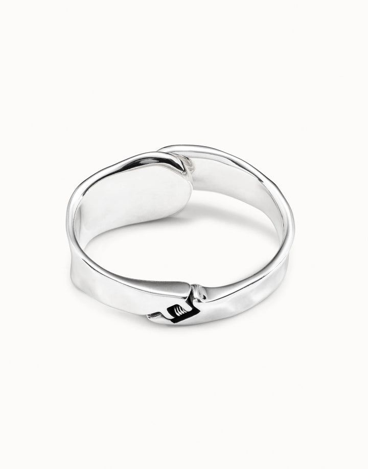 Minimalist polished silver bangle bracelet, handcrafted in Spain with a wrapped belt and small buckle detail at the front. Available in S, M, and L sizes.