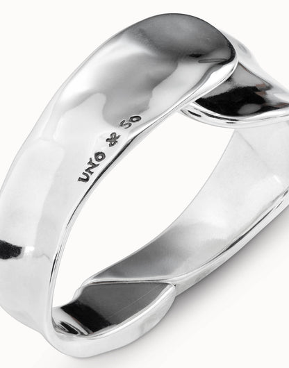 Shiny, silver, irregularly-shaped minimalist bangle bracelet, engraved with "UNO de 50" and a small symbol on the inner surface; handcrafted in Spain. Available in multiple sizes.