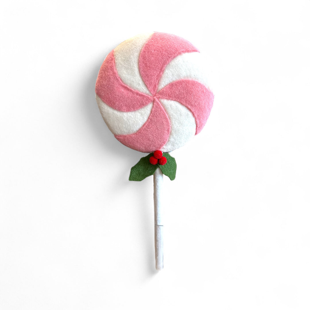 Handmade wool felt lollipop with pink and white swirl, holly leaves, and red berries.