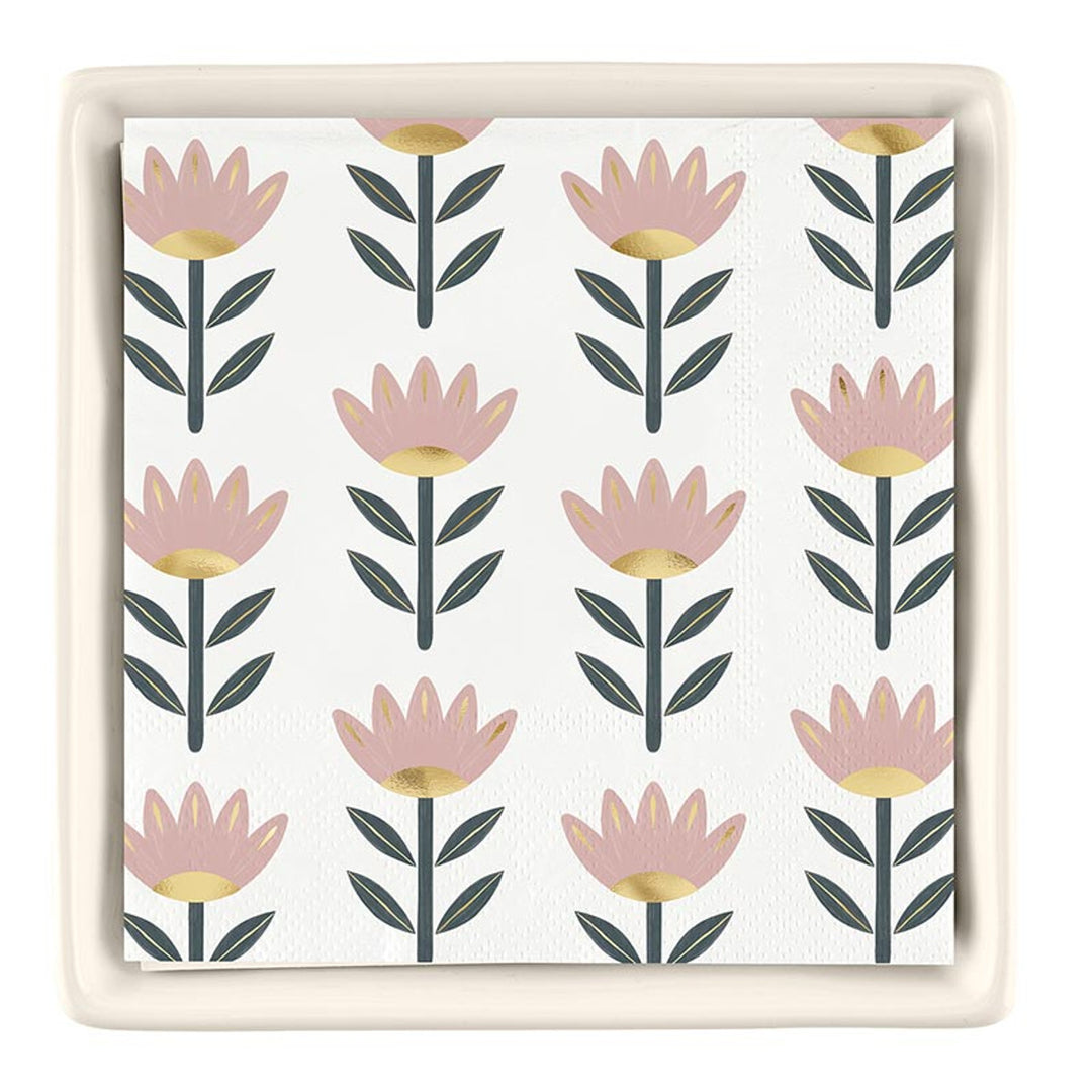 The Ceramic Napkin Tray + Napkins Set features a white napkin with pink and gold floral designs, complemented by green leaves. No specific sizes available.