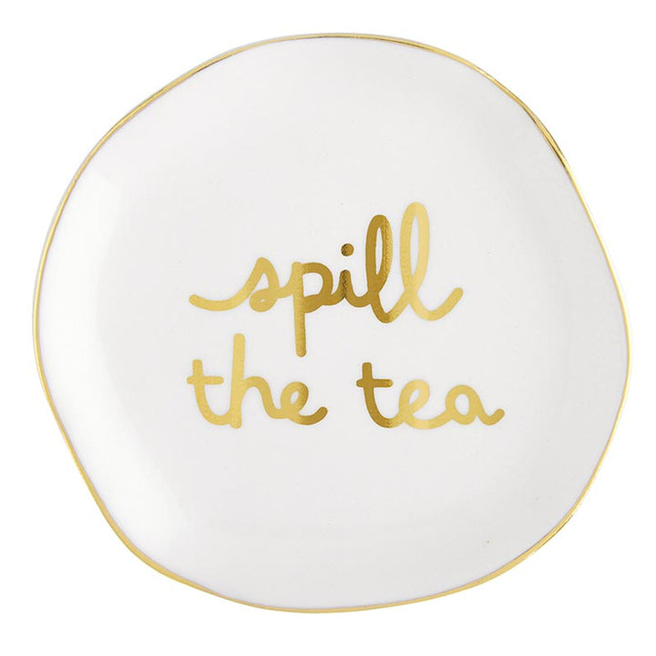 Round white ceramic tea bag holder with uneven edges, gold rim, and "spill the tea" in cursive gold lettering. Size: Not specified.