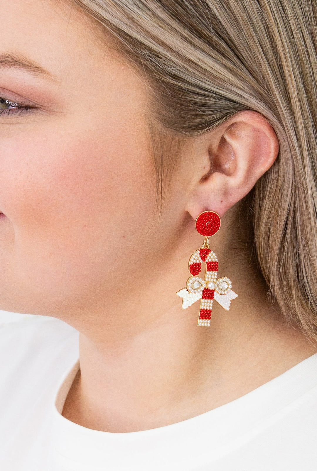 Candy cane earrings with red and white beads and a white bow. Available in all sizes.