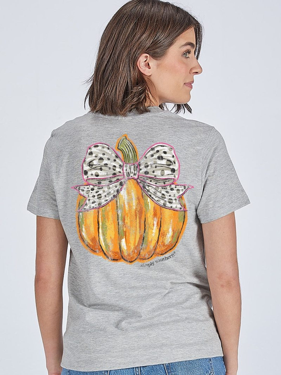 Polka Dot Bow Pumpkin Heather Gray T-Shirt by Simply Southern with a back graphic of an orange pumpkin and a large white bow covered in black polka dots; available in sizes S-XXL.