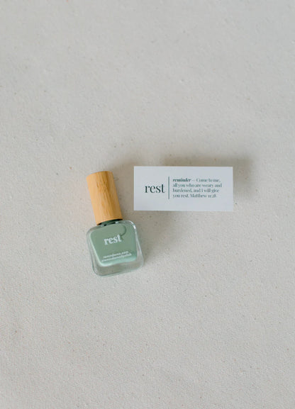 'Sage green "rest" nail polish with wooden cap; available in 10ml and 15ml sizes.'.