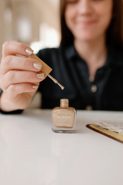 Open bottle of "heaven" shiny gold nail polish with applicator brush; available in 10ml and 15ml sizes.