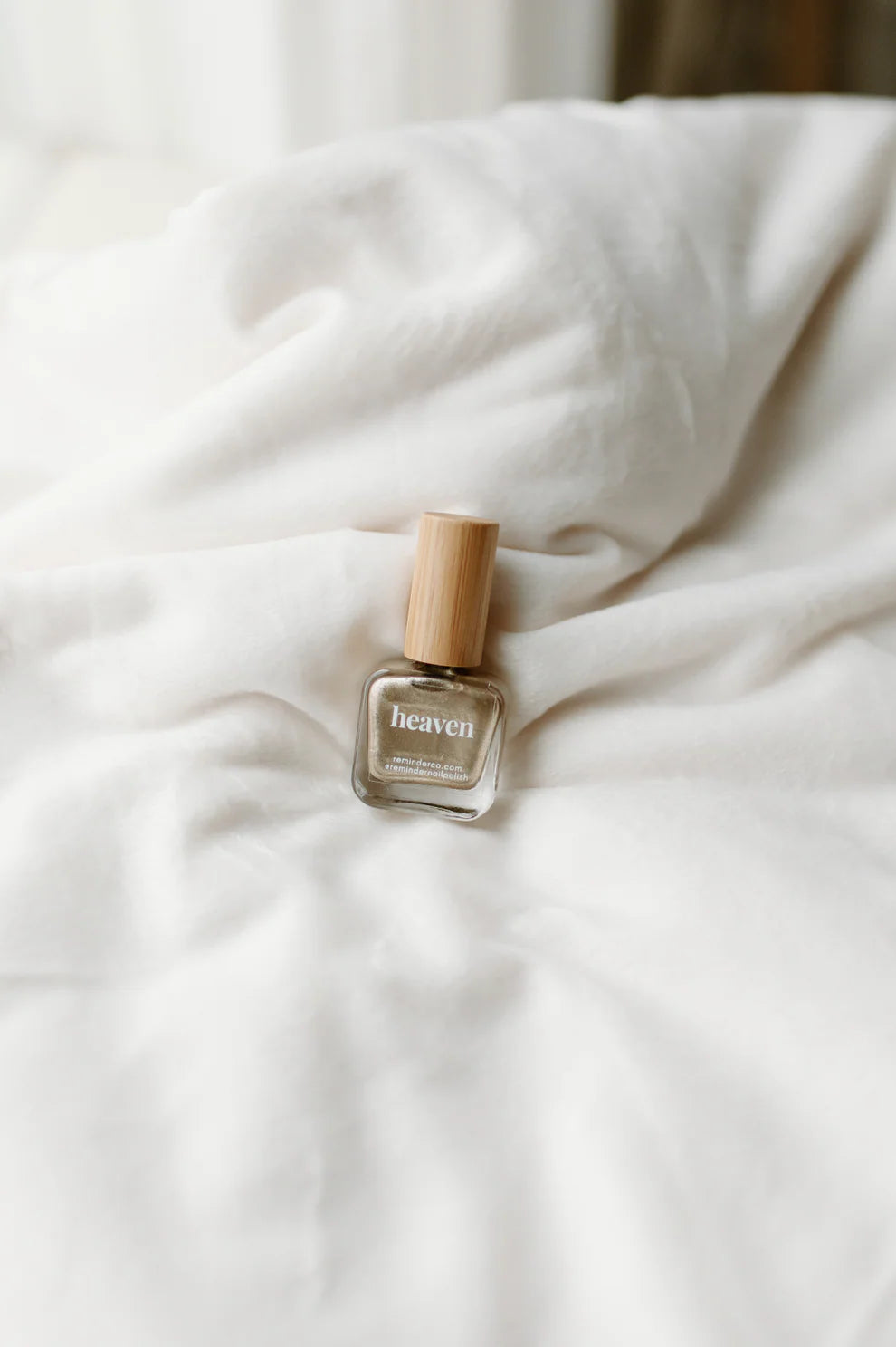 Small glass bottle of ‘heaven’ shiny gold reminder nail polish with wooden cap; available in 10ml and 15ml sizes.