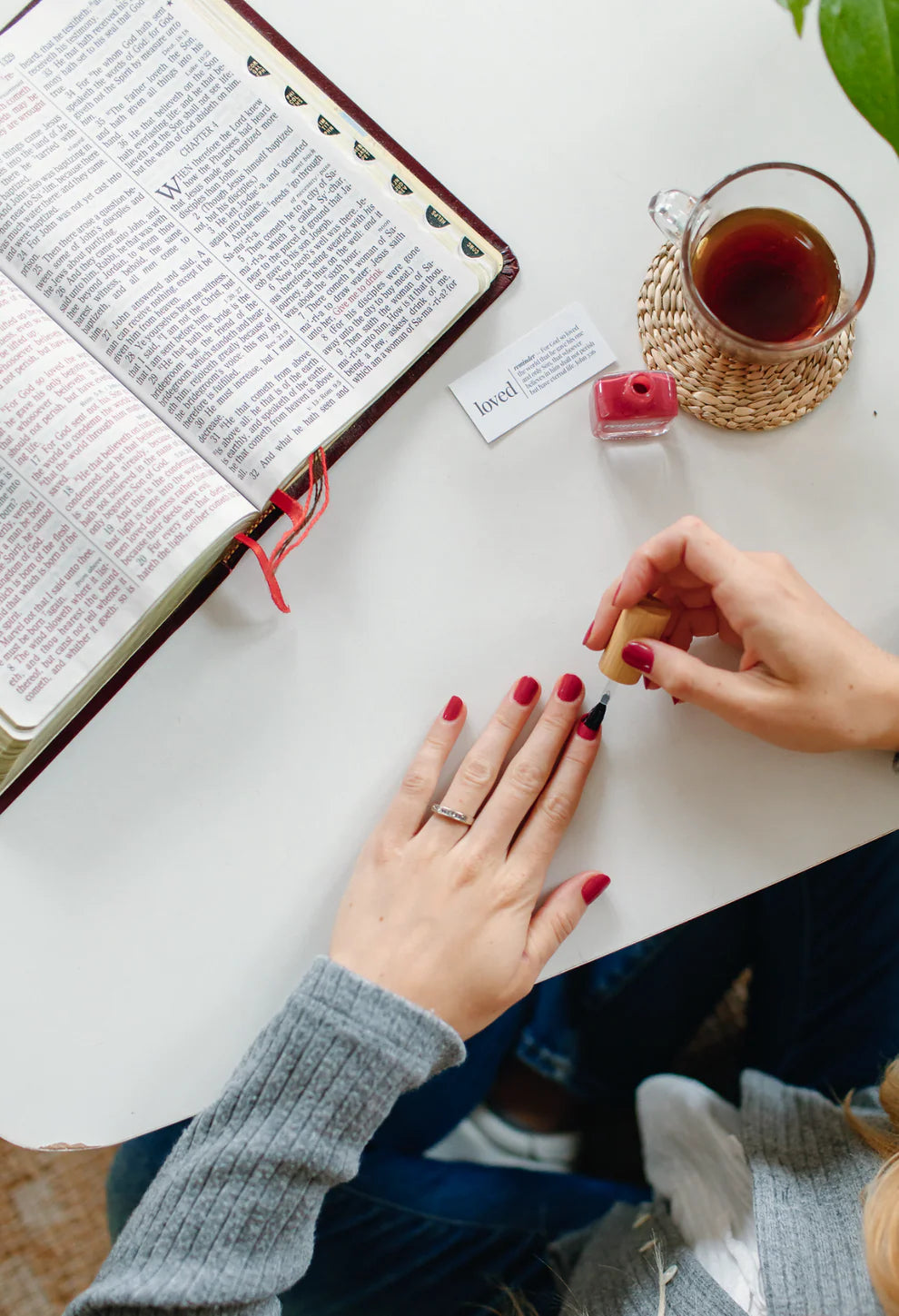 ‘Loved’ reminder nail polish in rose red shown in use; available in 10ml and 15ml sizes.