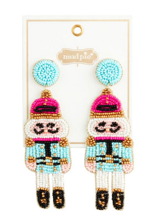 Holiday Beaded Earrings on Mud Pie card. Features pink hat, blue upper body, gold and black shoes, round blue bead on hypoallergenic posts. Available in 3 styles.