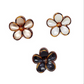Set of three five-petal, flower-shaped claw clips with brown tortoise-print edges in beige, white, and black. Sizes: one size.