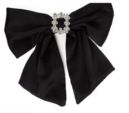 The Holiday Bows: Black satin-like bow with a silver-colored brooch encrusted with small, sparkling gems. Features two long tails. Sizes: N/A.
