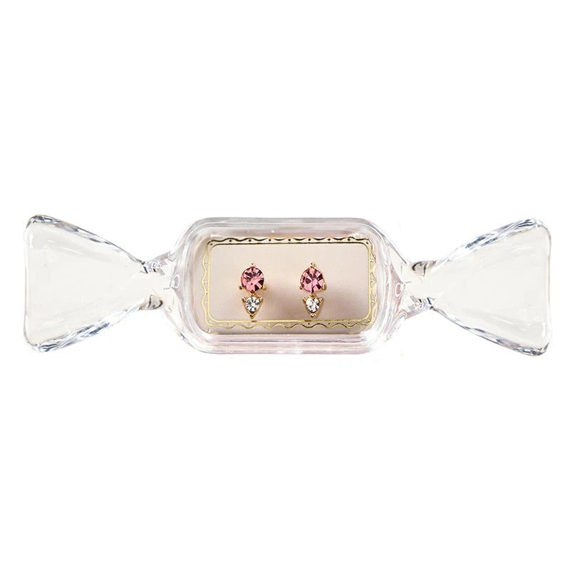 Sweet &amp; Sparkly Candy Dish stud earrings with a pink circular stone and clear triangular stone in candy-shaped packaging.