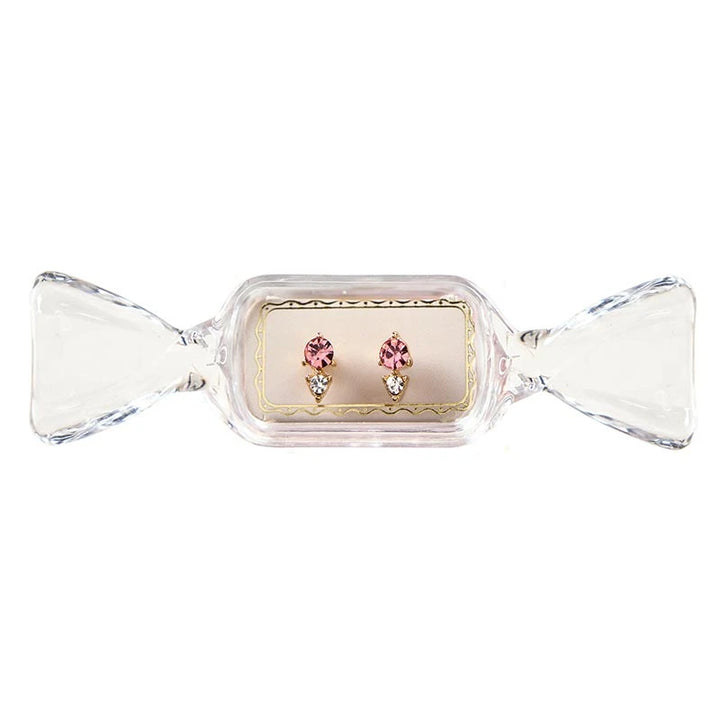 Sweet &amp; Sparkly Candy Dish stud earrings with a pink circular stone and clear triangular stone in candy-shaped packaging.