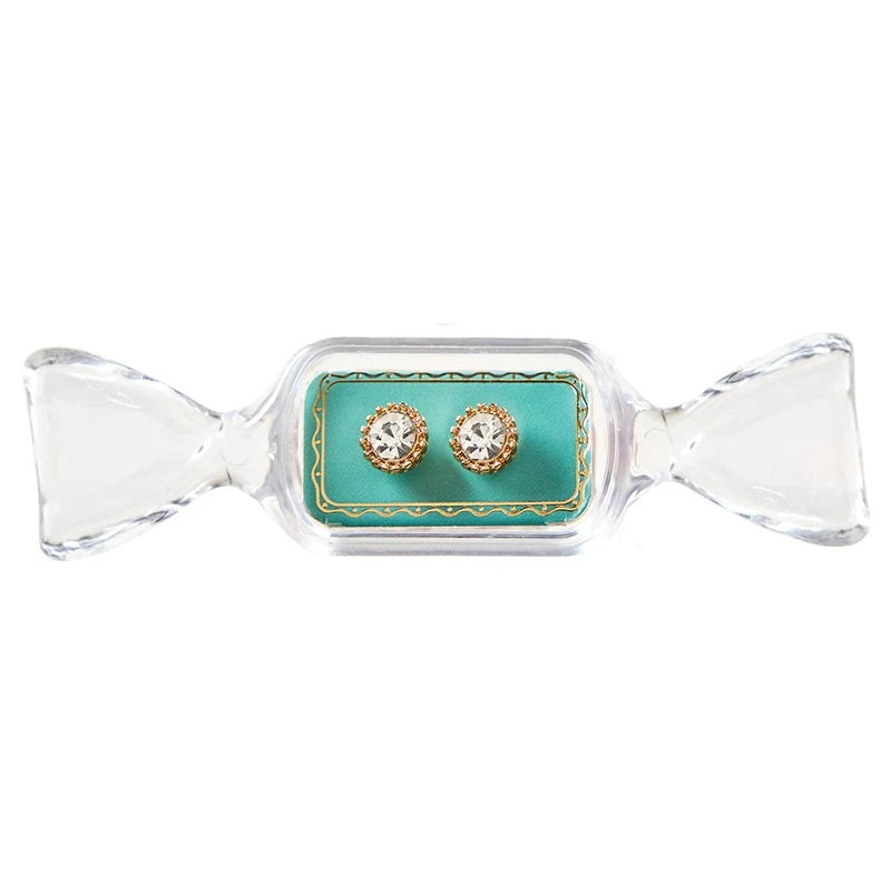 Round gold stud earrings with clear crystals in a candy-shaped display case.