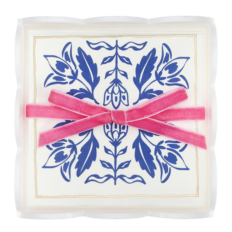 Acrylic cocktail napkin tray set with crisp white napkins featuring blue damask patterns, arranged in a clear tray and tied with a pink velvet ribbon bow. Sizes available: standard cocktail napkin size.