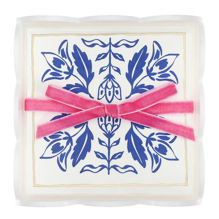 Acrylic cocktail napkin tray set with crisp white napkins featuring blue damask patterns, arranged in a clear tray and tied with a pink velvet ribbon bow. Sizes available: standard cocktail napkin size.