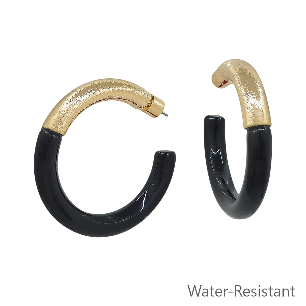 Gold-toned and glossy black resin hoop earrings with a contemporary design. Available sizes: small, medium, large. Water-resistant.