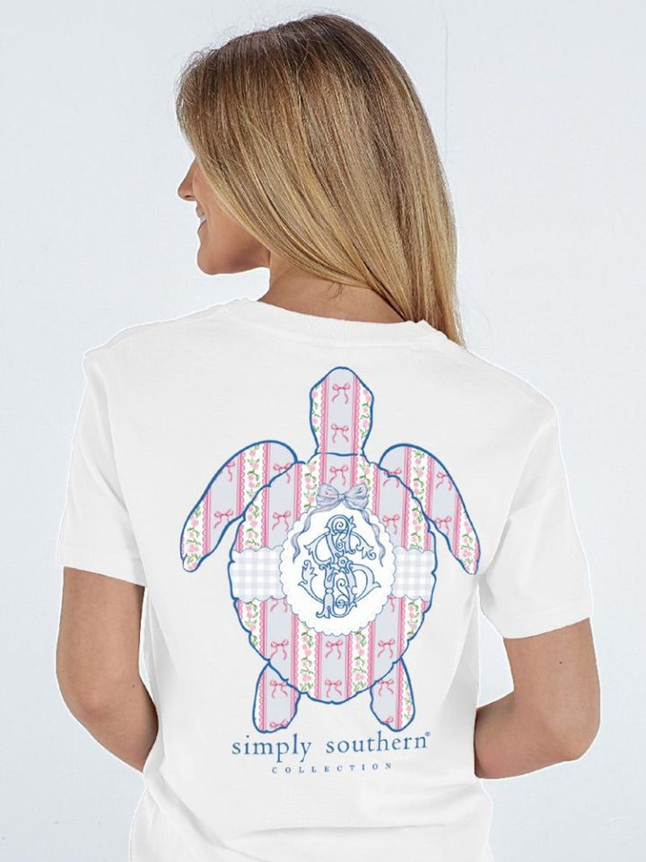 White Simply Southern Coquette Logo Turtle T-Shirt with patterned sea turtle, blue monogram, and text. Sizes: S-XL.