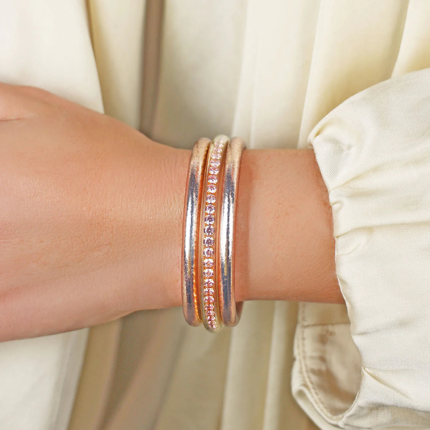The Champagne Queen Stack is a waterproof silver bangle with pink and clear gemstones. Available in S, M, L.