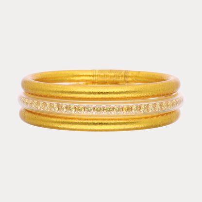 Gold ring with matte finish, three parallel bands, center band set with small clear gemstones. Available in sizes 5-9.