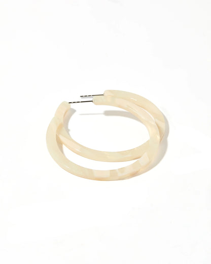 Cream-colored, semi-translucent hoop earring with silver surgical steel post. Available in small and medium sizes.