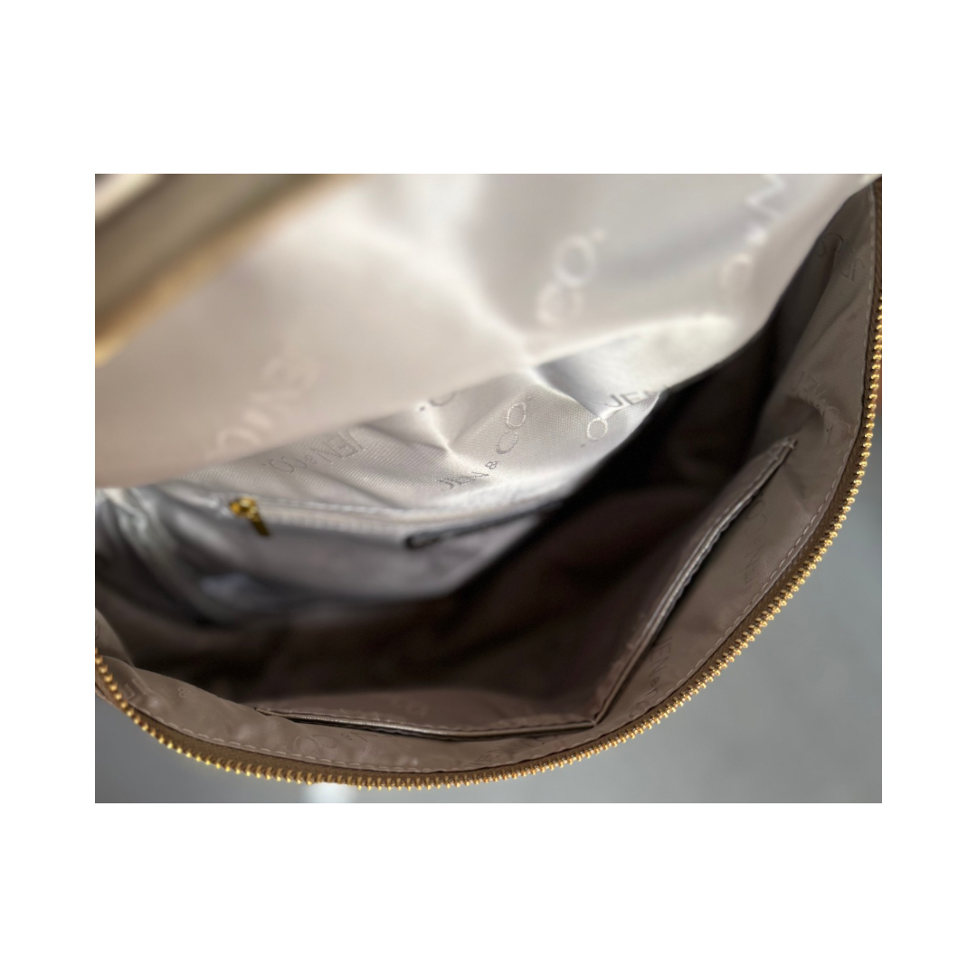 Close-up of Megan Sling Bag’s brown vegan leather interior, beige lining, pockets, gold zipper. Available in small and medium.