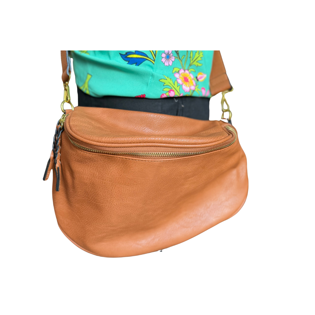 Megan Sling Bag: light brown vegan leather crossbody with zipper, metal clasps, adjustable strap. Sizes: S, M, L.