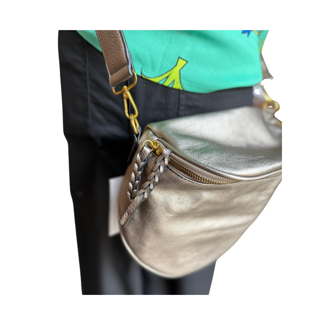 Megan Sling Bag: metallic gold vegan leather, adjustable strap, braided zipper pull, brown accent. Sizes: S, M, L.
