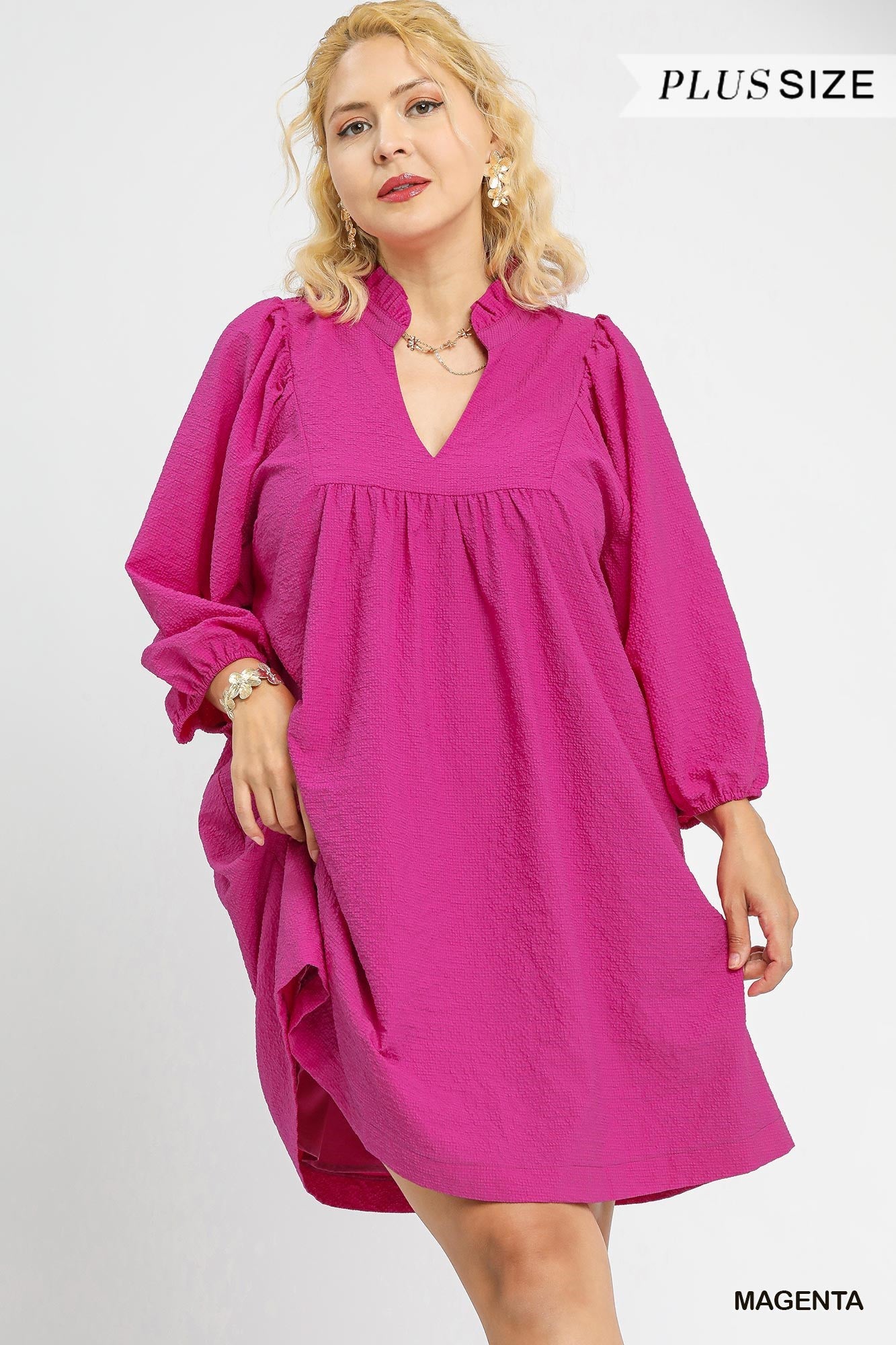 Magenta knee-length plus-size babydoll dress with textured puff sleeves, ruffled V-neck. Available in sizes 1X-4X.